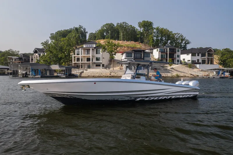 The Image of 2022 Fountain 38 SC boat cruising on a lake with waterfront homes in the background. - 1