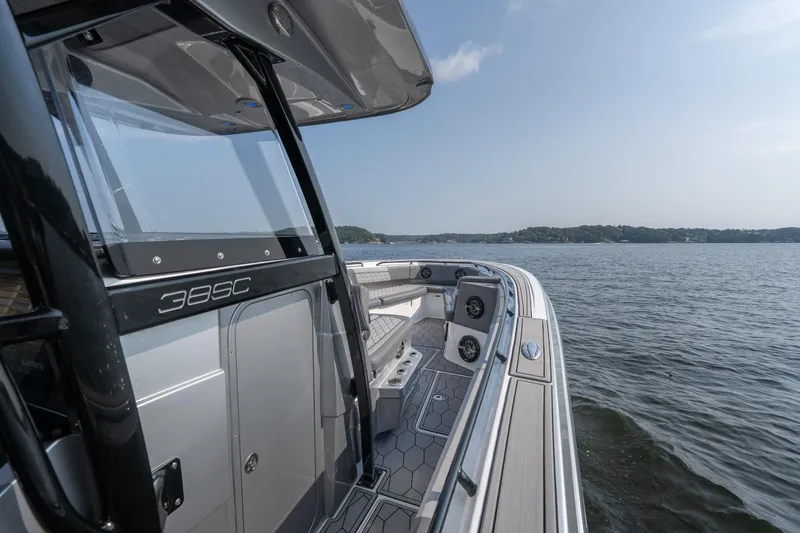 Slide: The Image of 2022 Fountain 38 SC boat on calm water, showcasing sleek design and spacious deck. - 28