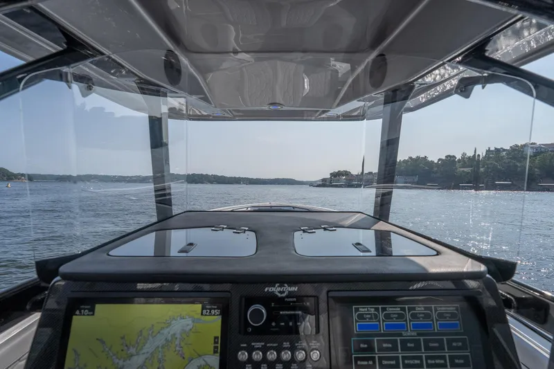 Slide: The Image of Cockpit view of 2022 Fountain 38 SC boat navigating a scenic waterway. - 20