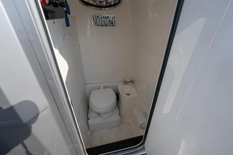 Slide: The Image of Interior of 2022 Fountain 38 SC boat bathroom with toilet and sink. - 21