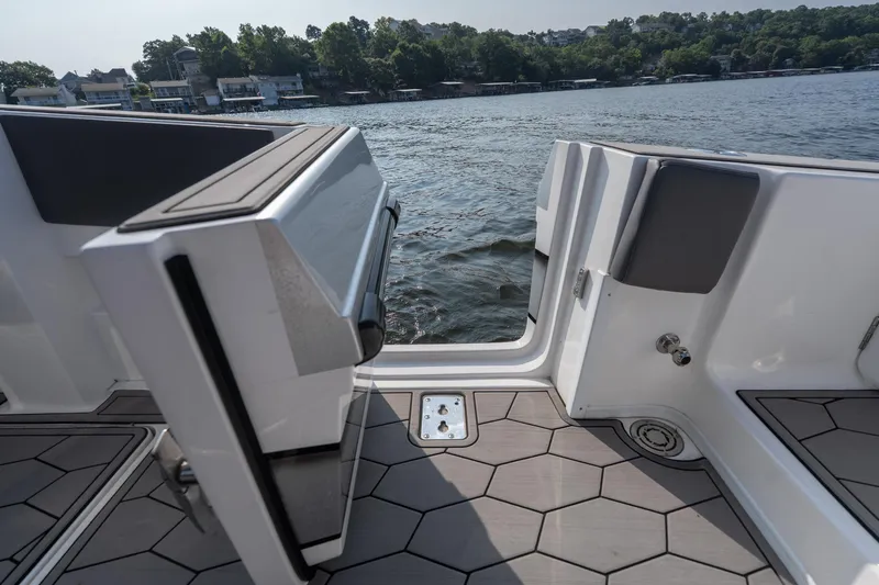 Slide: The Image of 2022 Fountain 38 SC boat with open side door, hexagonal deck pattern, and scenic water view. - 26