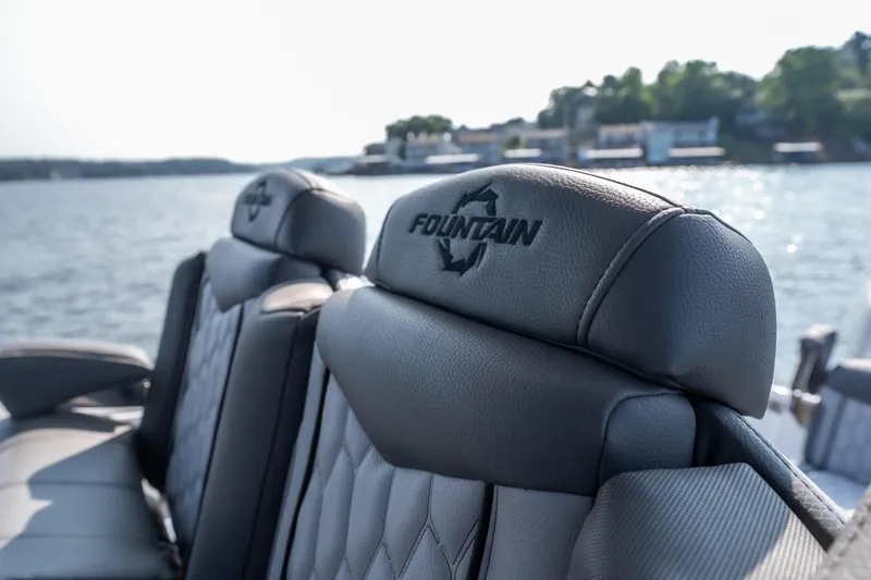 Slide: The Image of 2022 Fountain 38 SC boat seats with logo, overlooking serene water and distant shoreline. - 35