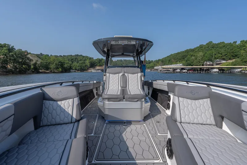Slide: The Image of 2022 Fountain 38 SC boat interior with luxurious seating on a scenic lake. - 14