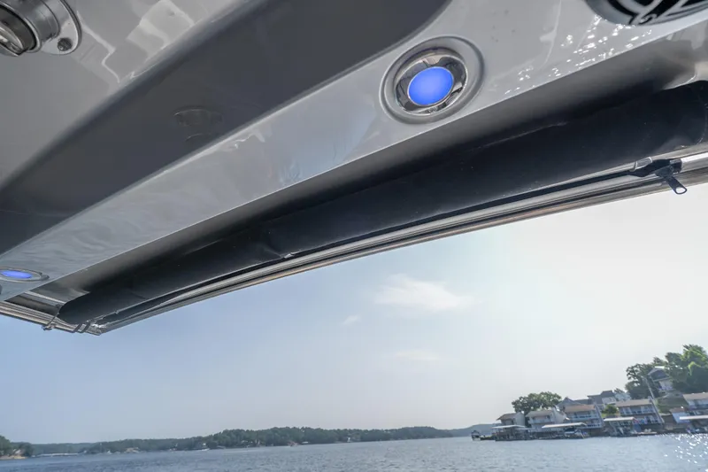 Slide: The Image of 2022 Fountain 38 SC boat with blue LED lights, overlooking a serene waterfront view. - 36
