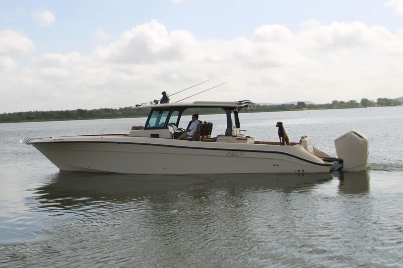 Slide: The Image of 2024 HCB 42 Lujo boat cruising on calm water with passengers and a dog. - 105