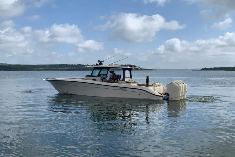 Slide: The Image of 2024 HCB 42 Lujo boat cruising on a calm lake under a partly cloudy sky. - 107