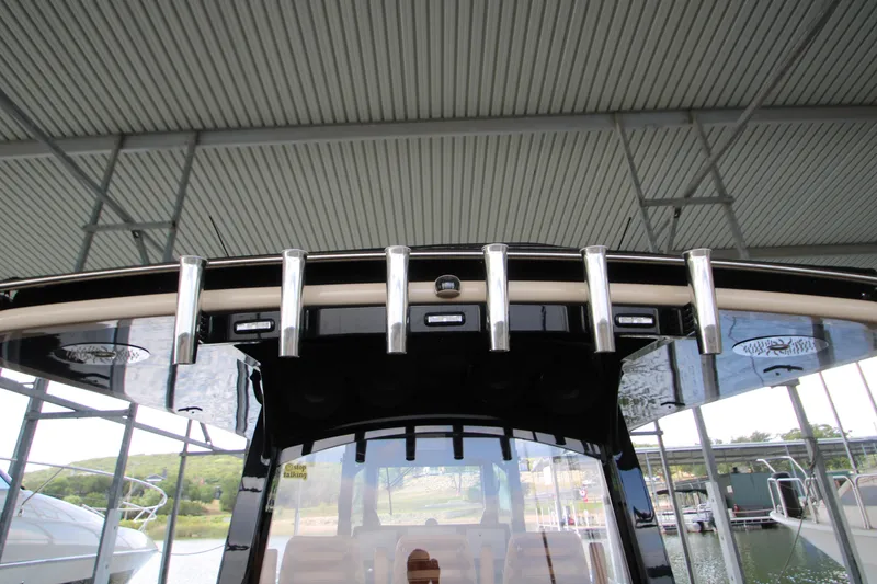 Slide: The Image of 2024 HCB 42 Lujo boat roof with rod holders under a covered dock. - 64