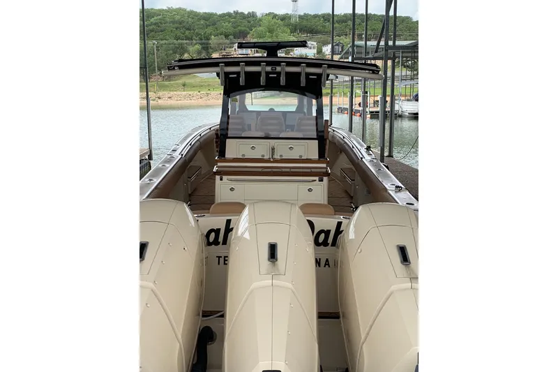 Slide: The Image of 2024 HCB 42 Lujo boat with triple engines docked by a scenic lake. - 72