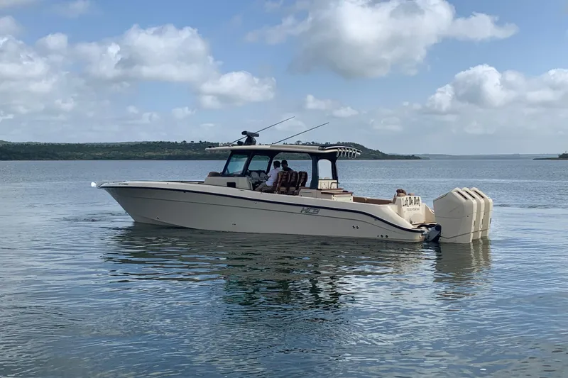 Slide: The Image of 2024 HCB 42 Lujo boat on calm water under a partly cloudy sky. - 108