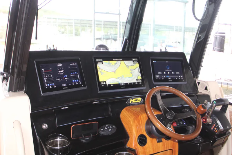Slide: The Image of Helm of 2024 HCB 42 Lujo boat with advanced navigation displays and controls. - 23