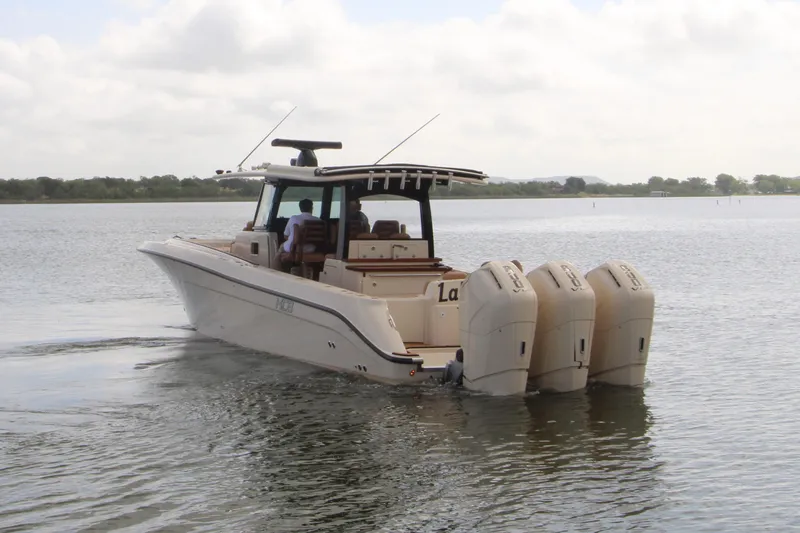 Slide: The Image of 2024 HCB 42 Lujo boat with four engines cruising on a calm lake. - 103