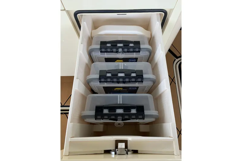 Slide: The Image of Storage compartment with organized containers on the 2024 HCB 42 Lujo boat. - 44