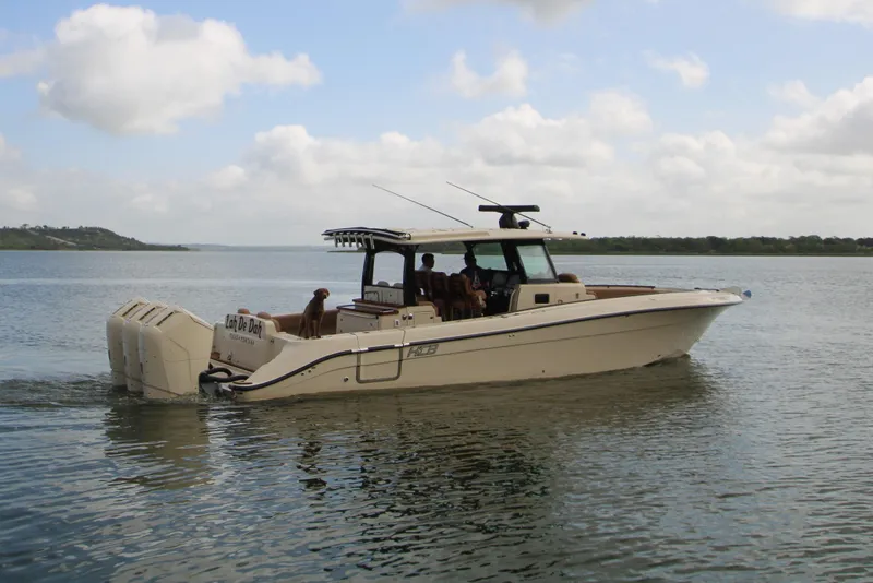 Slide: The Image of 2024 HCB 42 Lujo boat cruising on a calm lake under a partly cloudy sky. - 6