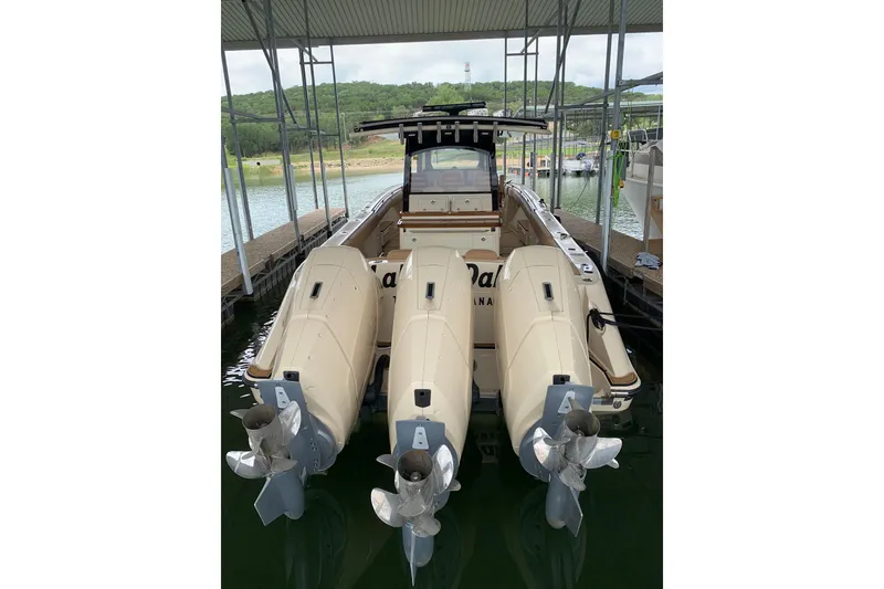 Slide: The Image of 2024 HCB 42 Lujo boat with triple outboard engines docked in a marina. - 69