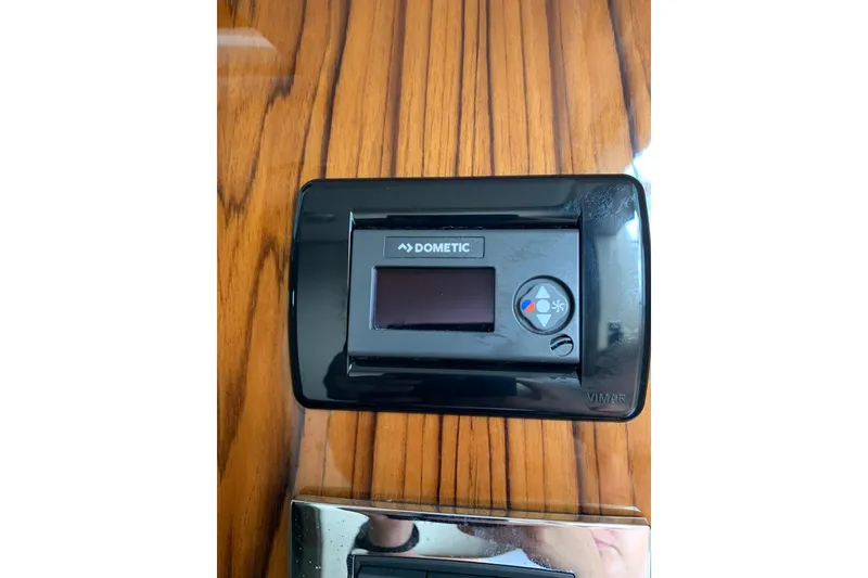 Slide: The Image of Dometic control panel on 2024 HCB 42 Lujo yacht, mounted on wood paneling. - 56