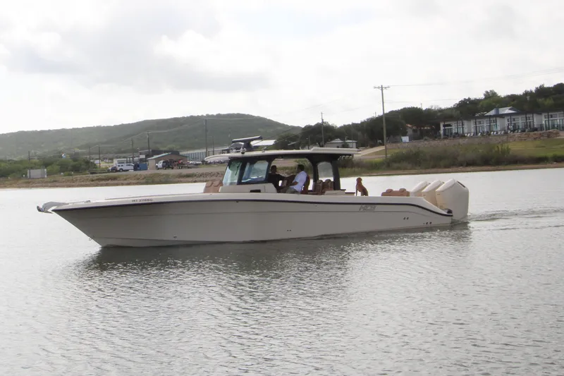 Slide: The Image of 2024 HCB 42 Lujo boat cruising on a calm lake with scenic background. - 110