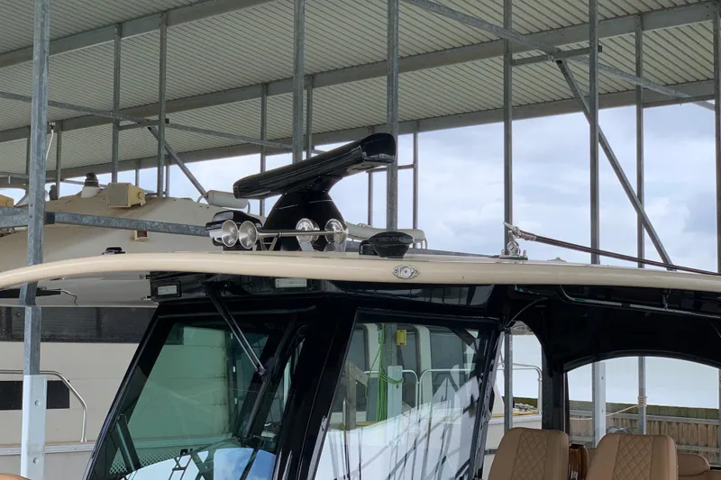 Slide: The Image of 2024 HCB 42 Lujo boat under a covered dock, showcasing its sleek design and modern features. - 79