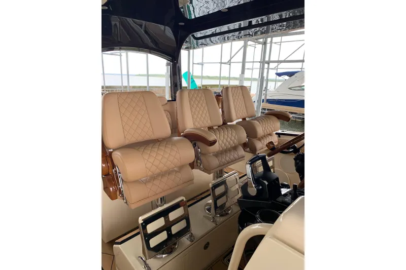 Slide: The Image of Luxurious seating on the 2024 HCB 42 Lujo boat, featuring tan quilted leather chairs. - 12
