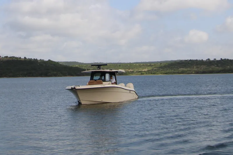 Slide: The Image of 2024 HCB 42 Lujo boat cruising on a serene lake under a cloudy sky. - 95