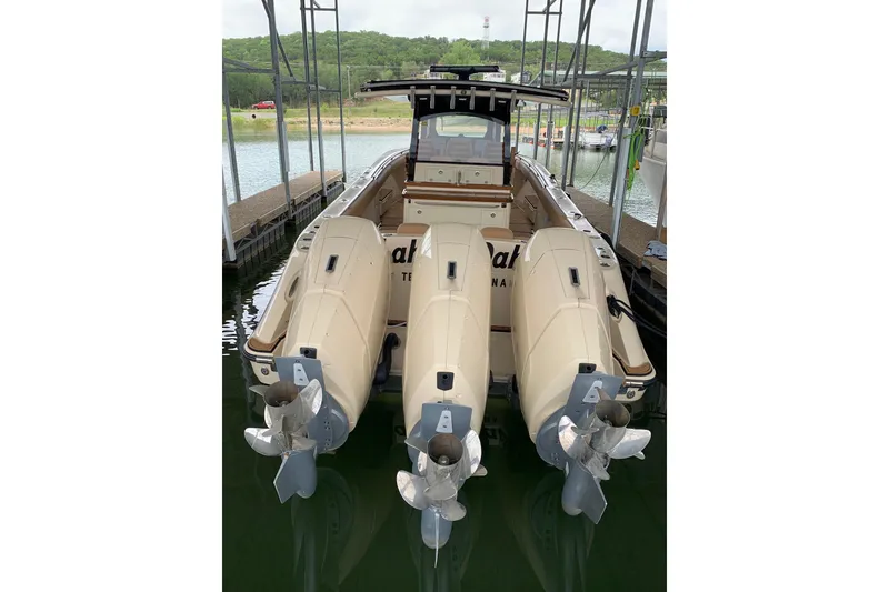 Slide: The Image of 2024 HCB 42 Lujo boat with triple outboard engines docked at a marina. - 71