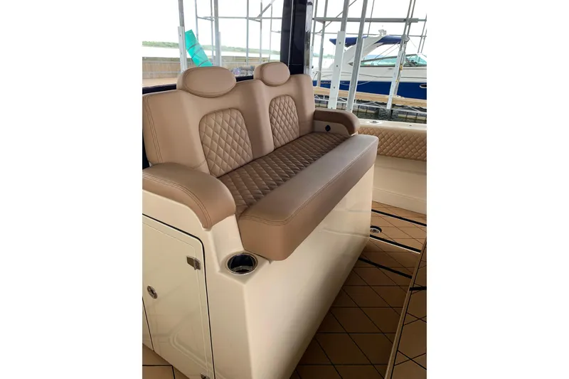 Slide: The Image of Luxurious seating on 2024 HCB 42 Lujo boat, featuring tan leather upholstery and diamond stitching. - 16