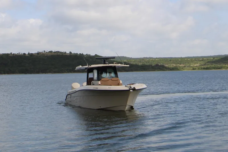 Slide: The Image of 2024 HCB 42 Lujo boat cruising on a serene lake under a cloudy sky. - 9