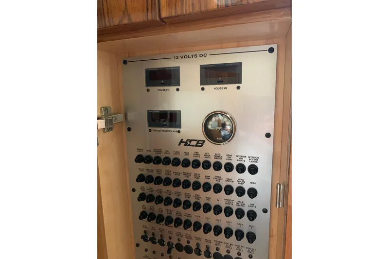 Slide: The Image of Electrical control panel of 2024 HCB 42 Lujo boat, featuring switches and gauges. - 60