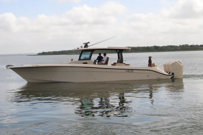 The Image of 2024 HCB 42 Lujo boat cruising on a calm lake with passengers onboard. - 0