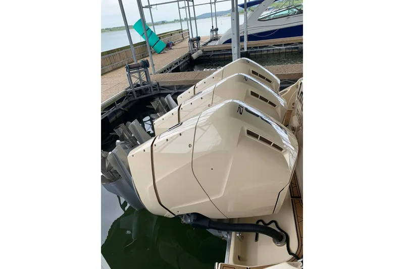 Slide: The Image of Triple outboard engines on a 2024 HCB 42 Lujo boat docked by the water. - 68