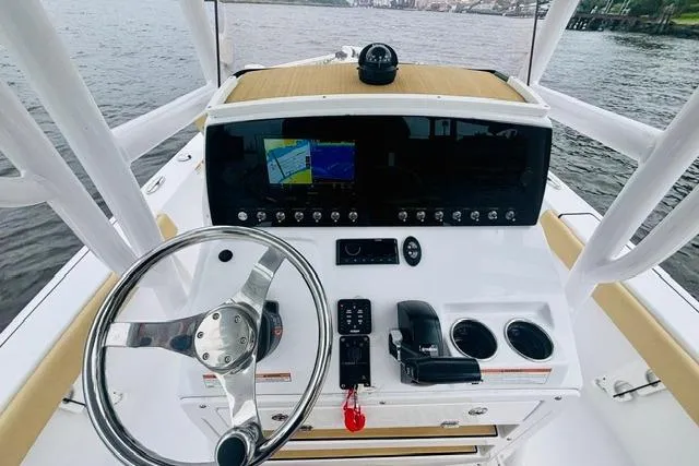 Slide: The Image of 2023 Sportsman Masters 227 Bay Boat dashboard with steering wheel and navigation system. - 6