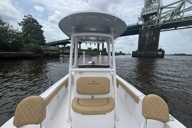 Slide: The Image of 2023 Sportsman Masters 227 Bay Boat cruising under a bridge on a calm river. - 12