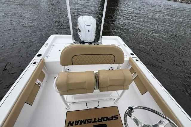 Slide: The Image of 2023 Sportsman Masters 227 Bay Boat interior with tan seating and steering wheel on water. - 9