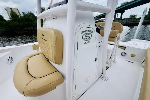 Slide: The Image of 2023 Sportsman Masters 227 Bay Boat interior with tan seating and console details. - 10
