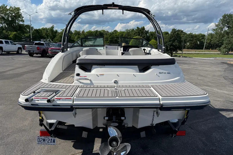 Slide: The Image of 2023 Sea Ray SPX 190 boat with swim platform, parked outdoors under a cloudy sky. - 4