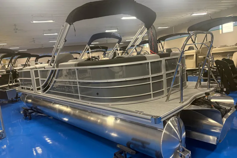 Slide: The Image of 2026 South Bay S224RS pontoon boat displayed indoors on blue flooring. - 3
