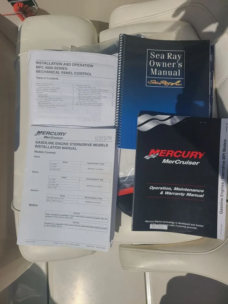 Slide: The Image of Manuals for Sea Ray 225 Weekender and Mercury engines are on a boat seat. - 5