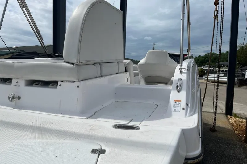 Slide: The Image of 2022 Hurricane SunDeck Sport 188 IO boat with white seating and deck, docked outdoors. - 16