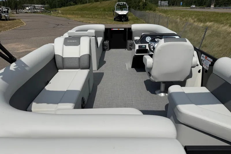 Slide: The Image of 2026 Crest Conquest SE220 Cruise pontoon boat interior with spacious seating and modern helm. - 2