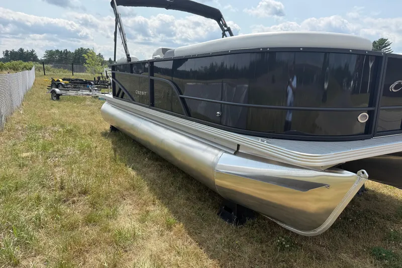Slide: The Image of 2026 Crest Conquest SE220 Cruise pontoon boat on grassy field under cloudy sky. - 7