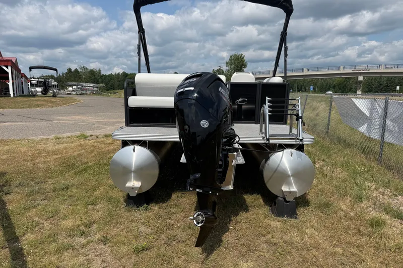 Slide: The Image of 2026 Crest Conquest SE220 Cruise pontoon boat with outboard motor, parked on grass. - 9