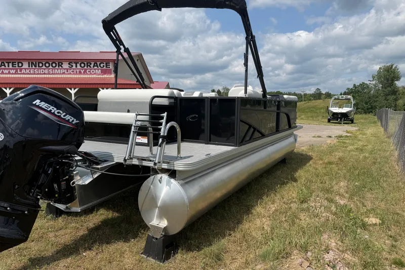 Slide: The Image of 2026 Crest Conquest SE220 Cruise pontoon boat with Mercury engine, parked outdoors. - 6