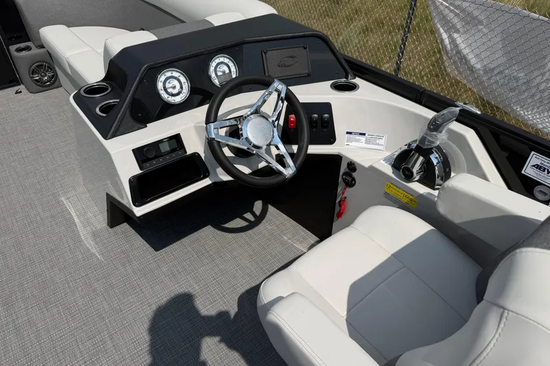 Slide: The Image of 2026 Crest Conquest SE220 Cruise boat interior with steering wheel and control panel. - 4