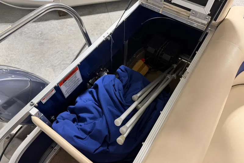 Slide: The Image of Storage compartment of a 2010 Bennington 20 SLI boat with blue cover and metal poles. - 19