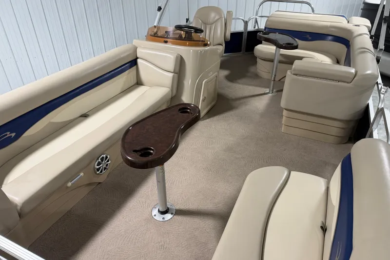 Slide: The Image of 2010 Bennington 20 SLI pontoon boat interior with beige seating and wood accents. - 6