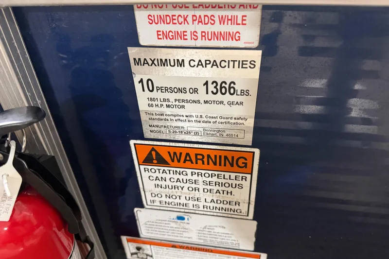 Slide: The Image of Warning labels on a 2010 Bennington 20 SLI boat, indicating capacity and safety instructions. - 15