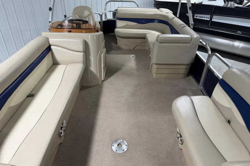 Slide: The Image of 2010 Bennington 20 SLI pontoon boat interior with beige seating and blue accents. - 8