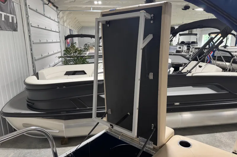 Slide: The Image of 2010 Bennington 20 SLI pontoon boat interior with open storage compartment in showroom. - 18