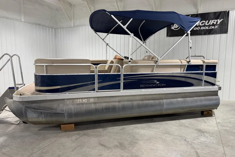 Slide: The Image of 2010 Bennington 20 SLI pontoon boat with blue canopy in indoor storage. - 4