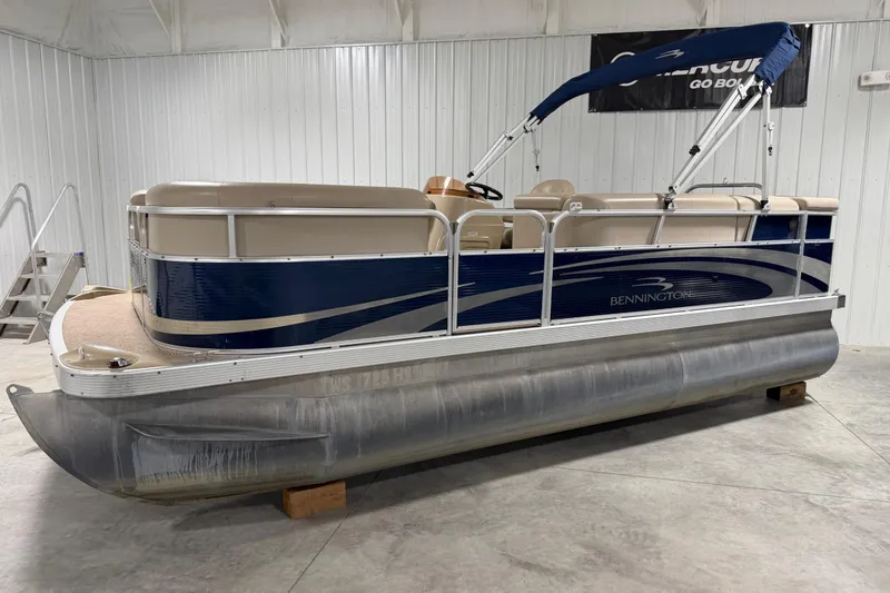 Slide: The Image of 2010 Bennington 20 SLI pontoon boat in a garage, featuring blue and beige design. - 12