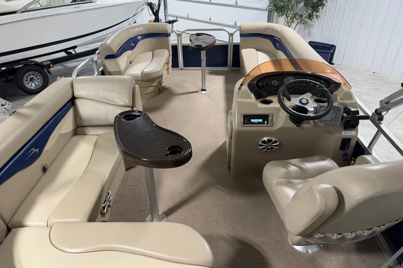 Slide: The Image of Interior of a 2010 Bennington 20 SLI pontoon boat with beige seating and steering console. - 2